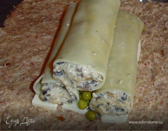 На сыр кладем 2 каннеллони и между ними - зеленый горошек.Сверху горошек прикрываем плавленым сыром и сверху прикрываем начиненными каннеллони.