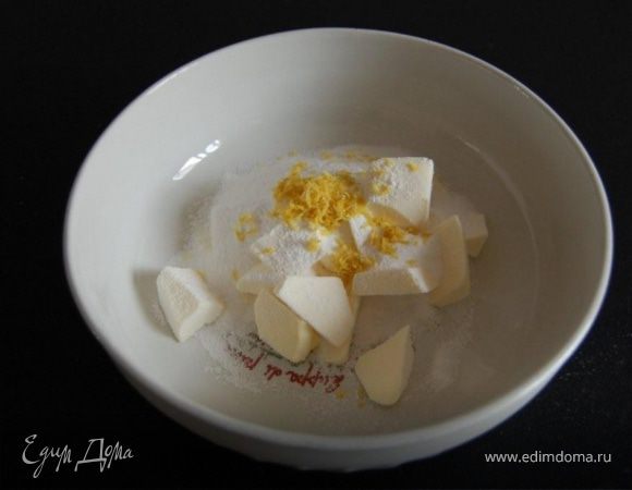 В миску выложить масло комнатной температуры, сахарную пудру, лимонную цедру и размять вилкой.