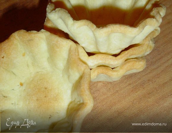 Готовим тесто для тарталеток, для этого в молоке растворить сахар, соль, часть муки и желток, и хорошо перемешать. Размягченный маргарин взбиваем, соединяем с приготовленной массой и остатком муки. 
Раскатываем тесто и вырезаем кружки по размеру формочек. Выкладываем кружочки в формы, смазанные маргарином, дно прокалываем вилкой.Выпекаем при температуре 200 гр. до золотистого цвета.  
