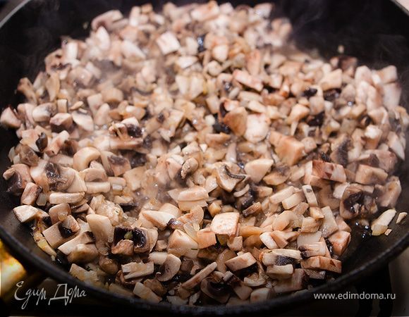 В это время моем, чистим и режем шампиньоны небольшими кубиками. Режем мелко луковицу. Кидаем грибы и лук на большую сковороду, разогретую с растительным маслом. Жарим на небольшом огне, помешивая, солим. 
