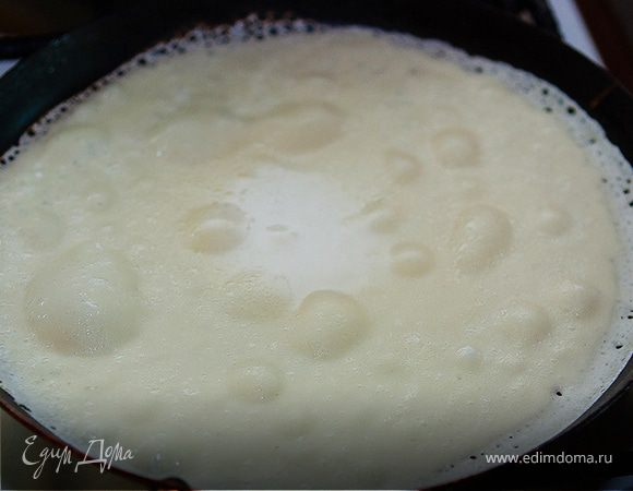 Добавляем в тесто растительное масло (1/3 стакана) и аккуратно перемешиваем половником. Первый раз на разогретую сковородку капаем каплю масла. Выливаем половником порцию теста на сковородку и переворачиваем после того, как края зарумянятся и появятся на тесте пузырики.