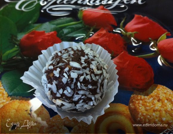 На водяной бане растопить шоколад с маслом. Печенье, миндаль измельчить в порошок. Добавить к шоколадной массе. Можно добавить пару капель миндальной эссенции.Пищевой контейнер (форму для выпечки) выстелить пищевой пленкой, выложить массу. Поставить в морозильную камеру на 1 час. Достать. Разрезать массу на части, размером приблизительно с грецкий орех. Руками сформировать шарики, обвалять их в кокосовой стружке. 
Можно также использовать сахарную пудру или какао. Очень сочные и аппетитные конфетки:) Приятного аппетита! 