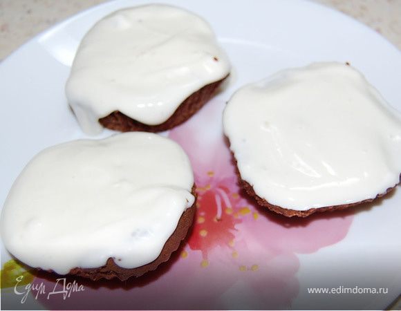 Охлажденные кексы разрезаем пополам (по горизонтали). Сметану размешать с сахарам (плюс ванильный сахар). Этим кремом намазать нижнюю часть кексов. Через минут 10-15 накрыть верхней половинкой.