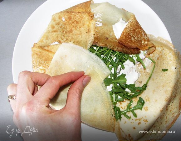 Аккуратно заворачиваем края блинчиков наверх.Следом сметану с сыром,блинчик сулугуни,снова сметану,потом руколу.Опять заворачиваем.Краешки смазываем сметаной,чтоб не разваливались.