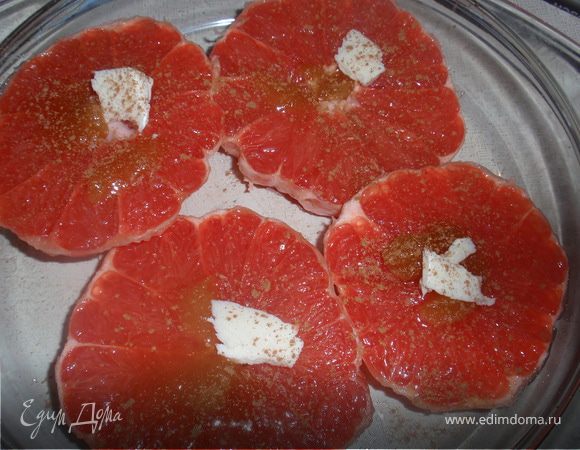 Выкладываем грейпфрут в форму для запекания. Поливаем каждый кусочек медом, сливочным маслом, посыпаем корицей.