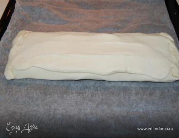 Накройте начинку тестом и залепите края. Поверхность смазать взбитым яичным желтком.