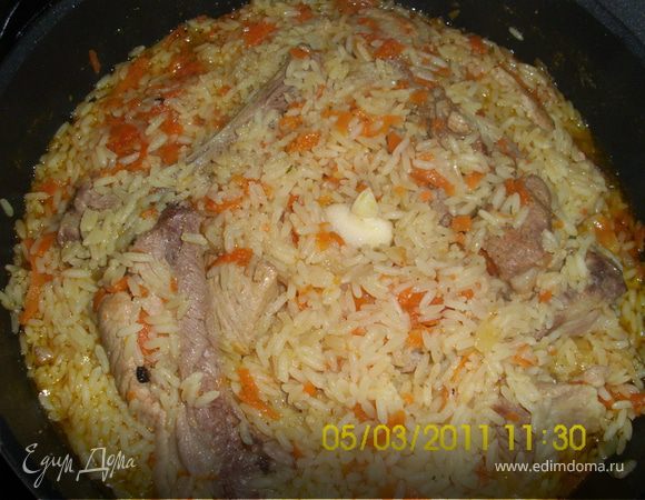 Лук нарезать кольцами, обжарить до золотистого цвета, морковь нашинковать, мясо ( у меня этот раз свинные рёбрышки) порезать, опустить в казан с луком, когда обжарится, опустить морковь, затем посолить, поперчить, залить кипятком (на высоту чайной ложки выше мяса) сделать медленный огонь и тушить 20 минут. Затем опускаем рис, разглаживаем, заливаем водой (на высоту пол чайной ложки), даём закипеть (крышку не закрывать). Когда рис разбухнет, огонь сделать медленный, рис перемешать, собрать горкой, воткнуть зубчики чеснока, плотно закрыть крышкой и на медленный огонь до готовности! Перед подачей чеснок вынуть и всё ещё раз хорошо перемешать.