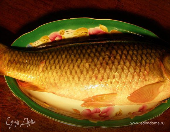 Картошку порезать тонкими кольцами, лук тоже кольцами. Ребу помыть, выпотрошить, форму застелить фальгой (чтобы потом можно было этой же фальгой закрыть рыбу сверху), затем на фальгу выложить слой сметаны, затем слой картошки, потом слой лука, посолить, поперчить, выдавить немного чеснока. Теперь выкладываем сверху рыбу, в рыбу натолкать зелень (петрушку, укроп). Сверху опять слой сметаны, лука, картошки, посолить, поперчить и посыпать сыром. Закрыть фальгой и выпекать в разогретой до 180 °С духовке минут 30-35. Приятного аппетита!