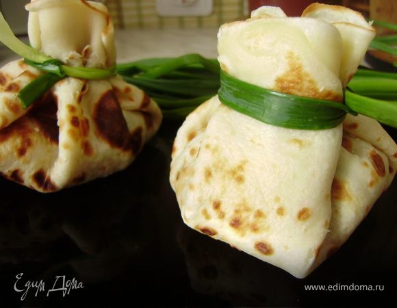 Теперь заворачиваем блинчики розочкой и перевязываем зеленым лучком... Причем в каждый блинчик вместе с начинкой кладем натертый сыр пармезан....На противень смазанный оливковым маслом и на 5 минут в духовой шкаф...