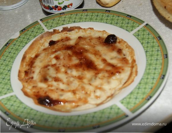 Выкладываем блин на блюдо и смазываем его клюквенным вареньем.