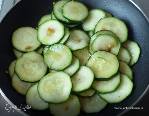 Цукини  помыть, нарезать кольцами и вместе с рубленым чесноком обжарить на масле в течение 2-х минут. Посолить, поперчить.