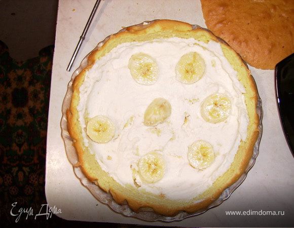 Мякоть бисквита поломать на крошки и смешать с 2/3 части всего крема.
Выкладываем слой крема и на него порезанный банан.