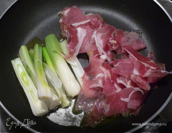 Ветчину нарезать небольшими кусочками и вместе с длинными кусочками лука обжарить в 2ст.л. горячего оливкового масла.