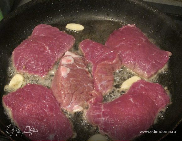 Говядину нарезать на длинные плоские куски, слегка отбить, посолить и поперчить. Быстро обжарить на сильно разогретой сковороде с дольками чеснока.