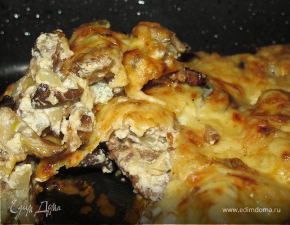 В жаропрочную форму выложить говядину, сверху грибы со сливками, посыпать  сыром и запекать 15 минут при температуре 200 гр.