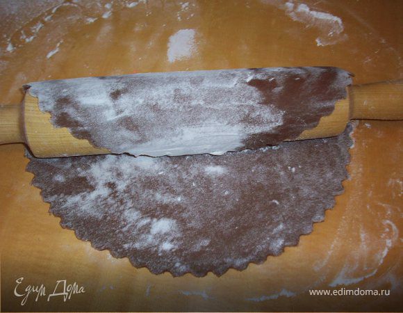 Остывшее тесто разделить на 5-6 частей (в зависимости от желаемого размера тортика).
Каждый кусочек раскатать толщиной 3 мм тщательно подпыляя стол и тесто мукой.
Вырезать заготовку необходимого диаметра и с помощью скалки перенести на противень посыпанный мукой.