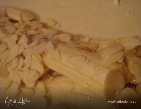 тесто разморозить при комнатной температуре и раскатать на присыпанном мукой столе (лучше раскатывать в одну сторону). Разогреть духовку до 220 гр.ц. Проложить тесто кусочками слив.масла и присыпать 1 ст.л. сахара. Вдаль теста по краю насыпать миндальные хлопья- сверху полить их медом.Бананы нарезать вдоль на полоски и положить на мед. Завернуть тесто вдоль один раз (прикрыть бананы). Края зажать,чтоб мед не вытек при запекании