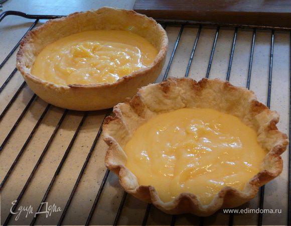 Для крема соединить 6 первых компонентов в кастрюльке на малом огне, взбивая. Когда загуснет, снять, добавить масло и цедру, взбить и довести до кипения. Остудить немного и вылить на тесто.
Для меренги- взбить до плотных пиков белки с сахаром и ванилью. Осторожно покрыть верх пирогов и отправить их на 10 мин в духовку при 170С. Остудить полностью и поставить в холодильник на несколько часов. 
Резать лучше теплым ножем.