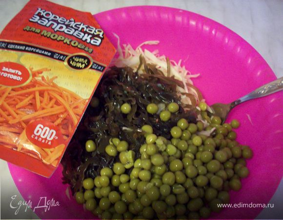 Добавить к капусте белокочанной капусту морскую, зеленый горошек, заправку для корейской морковки и оливковое масло. Тщательно размешать.