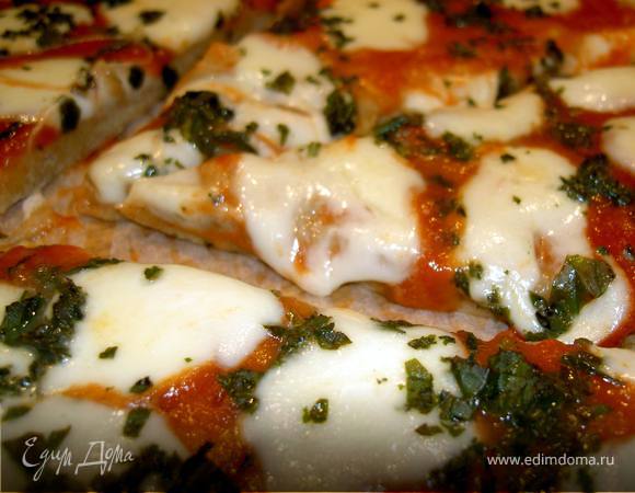 Выпекать в разогретой до 220С духовке 6-8 минут. Готовую пиццу посыпать базиликом.