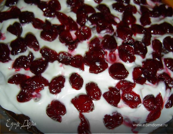 Корж смазываем кремом, сверху выкладываем вишни, а сверху - еще крем.