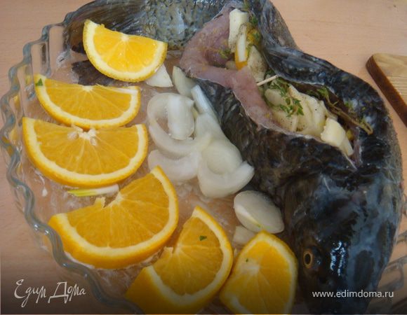 Карпа посолить поперчить изнутри и снаружи. Форму для запекания смазать слив.маслом. Внутрь карпа выложить начинку: лук репчатый зук зеленый с цедрой, апельсины, сверху порезанный кубиками сулугуни и веточки тимьяна. Переложить рыбку в форму. Обложить апельсиновыми дольками (вторая половина апельсина) и крупнопорезанной второй головкой лука. Сверху рыбу сбрызнуть лимонным соком и прикрыть фольгой (блестяшкой внутрь). Запекать в духовке 30 минут при температуре 200 гр.Ц. Снять фольгу и запекать еще 20-30 минут до зарумянивания.
