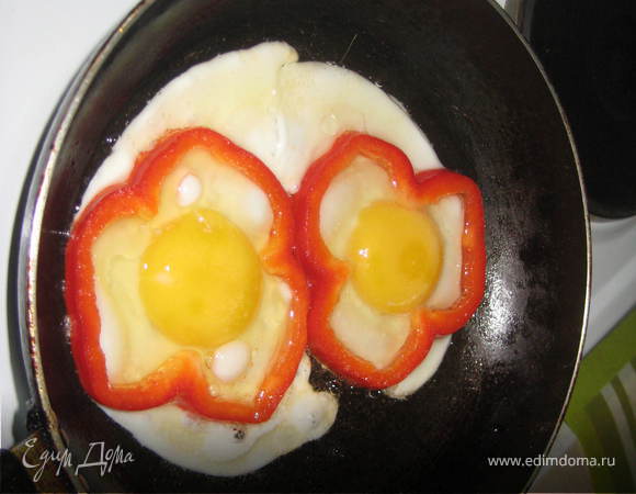 Почистить перец и порезать колечками.Обжарить слегка на растительном масле в сковороде и разбить внутрь колец перчика яйца!Жарить до готовности,украсить зеленью!