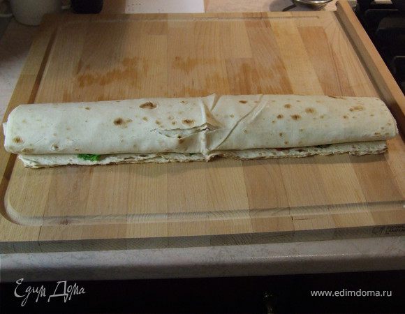 Аккуратно закручиваем лаваш в рулет.
Нарезаем на кусочки толщиной 2-3 см