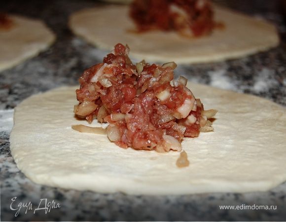 Каждый шарик раскатайте в круг толщиной 3–4 мм. На середину положите начинку.