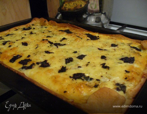 Яйца немножко взбить венчиком, перемешать с тертым сыром, вылить в форму.
Загнуть бортики к центру.
Присыпать пирог базиликом.
Отправить в духовку минут на 20, до готовности теста.