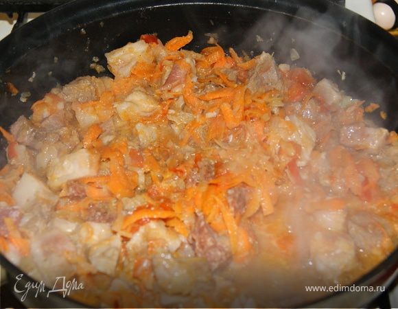 Мелко нашинкуйте лук, морковь натрите на крупной терке. Разогрейте в глубокой сковороде сливочное и оливковое масло, обжарьте лук и морковь. Мелко нарежьте помидор и чеснок, добавьте в сковороду. Нарежьте свинину на кубики и отправьте к овощам. Добавьте соль и перец.
