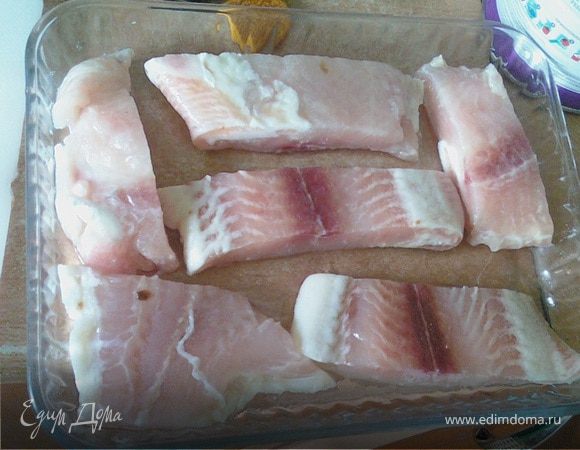 Порезать филе рыбы и уложить на противень