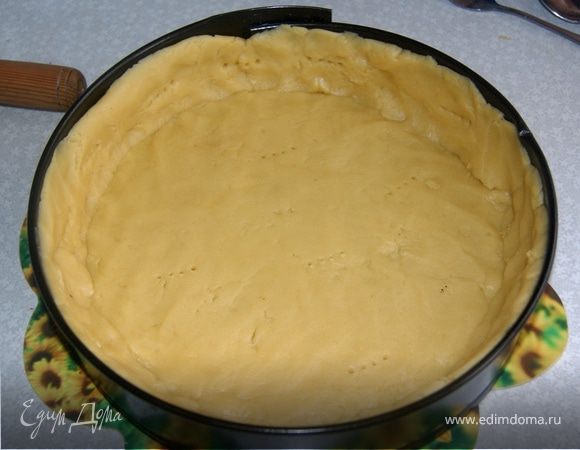 Смазать разъемную форму маслом, лучше сливочным или маргарином, и простелить бумагой для выпечки. Раскатать тесто толщиной 0,5 см. Распределить тесто по форме, вилкой сделать дырочки, чтобы тесто дышало. 