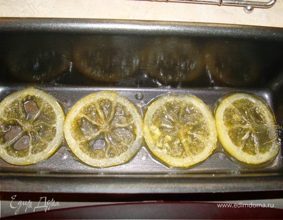 Так как теста получилось много, то я одновременно использовала и формы для маффинов и большую форму для кекса. Смазать формы сливочным маслом. На дно каждой формы положить закарамелизированные кружки лимона, сверху – тесто. Причем тесто во время выпечки стало подходить больше, чем я ожидала, поэтому сразу предупреждаю, что теста в форме должно быть только наполовину, а не 2/3 как обычно. 