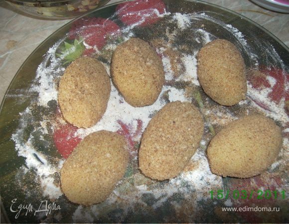 Тесто мокрыми руками разделить на шарики,сформировать лепешки,выложить на них начинку,края защипнуть,обвалять в сухарях.