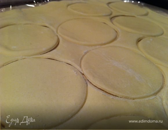 Духовку разогреть до 180С. Открыть банку с ананасами. Достать ананасы. Дать стечь соку. Тесто разморозить. Раскатать толщиной в 0,5 см.Взять круглую форму (у меня стакан), равную по диаметру ананасовому кружку или чуть больше его. Вырезать кружочки на тесте.