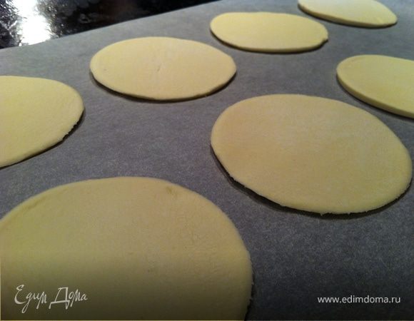 Противень застелить бумагой для выпечки. Переложить кружки из теста на бумагу.