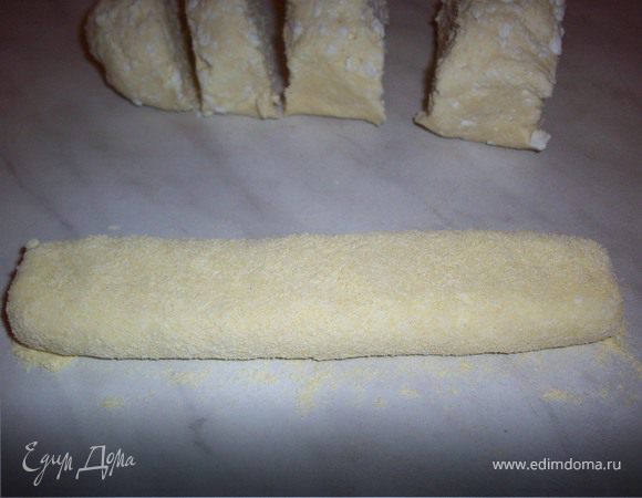 Для вареников колбаску раскатать тонкую, запанировать ее в муке и нарезать на небольшие кусочки.