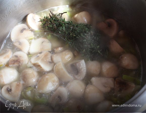 В кастрюле растопить и нагреть масло. Обжарить лук с чесноком. Добавить картофель и грибы. Перемешать. Влить кипяченой воды. Положить пучок тимьяна.