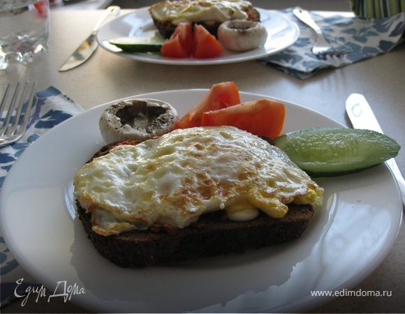На сильно разогретой сковороде в небольшом количестве растительного масла обжарить яйцо с двух сторон так, чтоб желток в середине оставался жидким. Затем выложить на гренку. Добавить ломтик свежего огурчика, помидорки, добавить парочку оливок (забыла положить :) исправлюсь) и вуаля! Ваш завтрак готов!