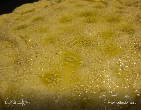 7.	Прикрыть второй частью и защипать края. На поверхности сделать пальцем углубления и очень-очень обильно смазать оливковым маслом и присыпать кунжутом и морской солью