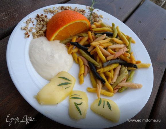 На теплые тарелки высыпать пасту.  Выложить сыр. Вылить соус. Посыпать миндалем. Рядом положить апельсин и веточку свежего розмарина...