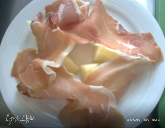 Разрезать дыню пополам и очистить от семян. Затем каждую половинку дыни разрезать на равные ломтики и удалите кожуру.
Разложить ломтики дыни и тонко нарезанную ветчину на тарелке.
Ветчину лучше нарезать при помощи слайсера - тогда ломтики ветчины будут очень тонкими и почти прозрачными, это добавит аппетитности блюду.