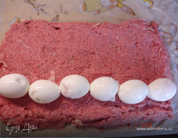 Лук мелко нарезать и обжарить. 
Соединить фарш, пассерованный лук, соль, перец, сырые яйца и сливки. Замешать котлетную массу. Застелить доску сырым кухонным полотенцем и разложить на нем ровным слоем котлетную массу толщиной 1,5-2см. На пласт выложить целые очищенные яйца.