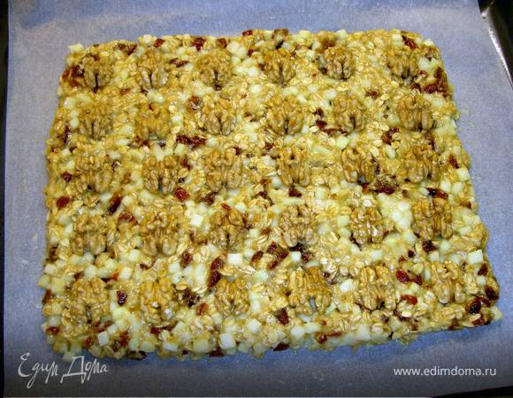 Застелить противень пергаментом. Выложить смесь, разровнять , придав прямоугольную форму. Украсить грецкими орехами.