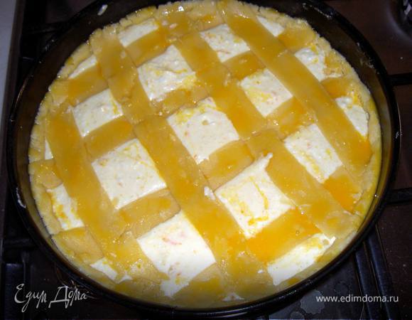 В разъемную форму выложить 2/3 теста, распредилить по дну , сделав высокий бортик. Наполнить творожной массой. Оставшееся тесто раскатать и нарезать полосками. Выложить на начинку в форме решетки. Смазать желтком.