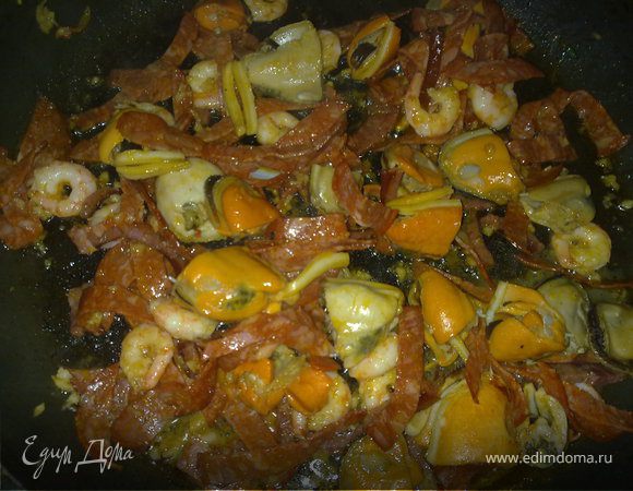 Колбасу  (чоризо) нарезаем "соломкой" и обжариваем на сковороде с оливковым маслом, добавить мелко нарубленный чеснок, потом очищенные креветки и мидии и на интенсивном большом огне все это перемешаем минут пять. 