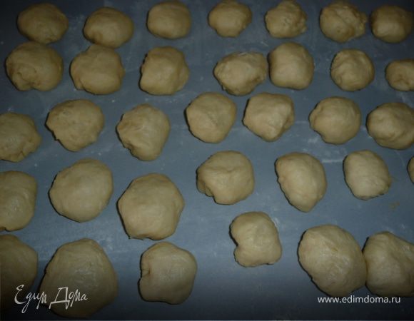 Выложить тесто на слегка присыпанную мукой поверхность, обвалять (тесто должно быть воздушным, но к рукам не липнуть). Разделить на 4-5 частей, из каждой сформировать "колбаску" толщиной около 4см, каждую поделить ножом на небольшие порционные кусочки-будущие пирожки (у меня получается от 50 до 60 штук среднего размера). 
Выложить эти кусочки, "вывернув" шариком, чтобы расстоялись. 