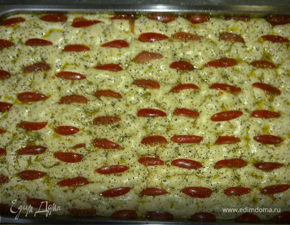 Подошедшее тесто выложите на стол, руками сформируйте прямоугольник (удобнее это делать на противне, на котором вы будете выпекать лепешку). Дайте тесту полежать 15 минут. Сделайте на фокачче углубления, в эти углубления положите четвертинки помидоров черри. Сбрызните оливковым маслом. Посыпьте черным молотым перцем (по желанию).