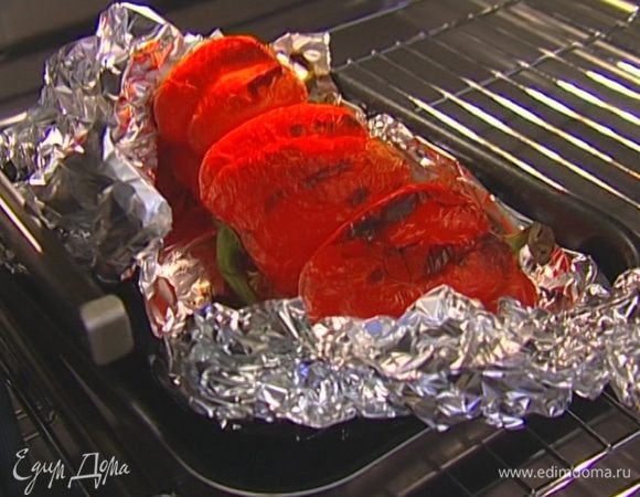 Перец вымыть, уложить в глубокий противень, закрыть пищевой фольгой и отправить в разогретую духовку. Когда на кожице появятся капли влаги, снять фольгу и допечь перец до готовности. 